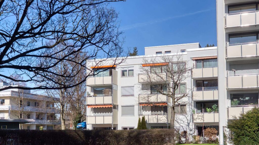 Wohnanlage mit verglasten Balkonen und Grünanlage in Solln, München
