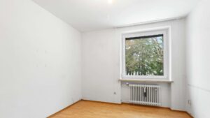 Leeres, frisch gestrichenes Zimmer mit hellem Parkett und Heizkörper unter dem Fenster in Solln