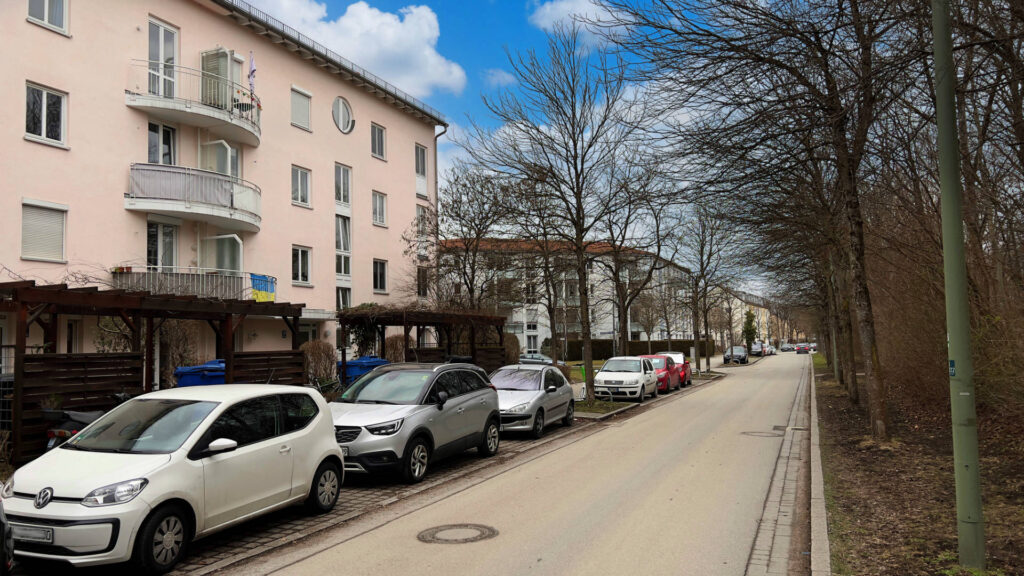 Residential building with parked vehicles along the street in the Untermenzing district of Munich