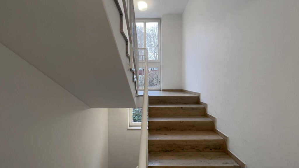 Stairwell with wooden steps and a window in an apartment building in the Untermenzing district of Munich