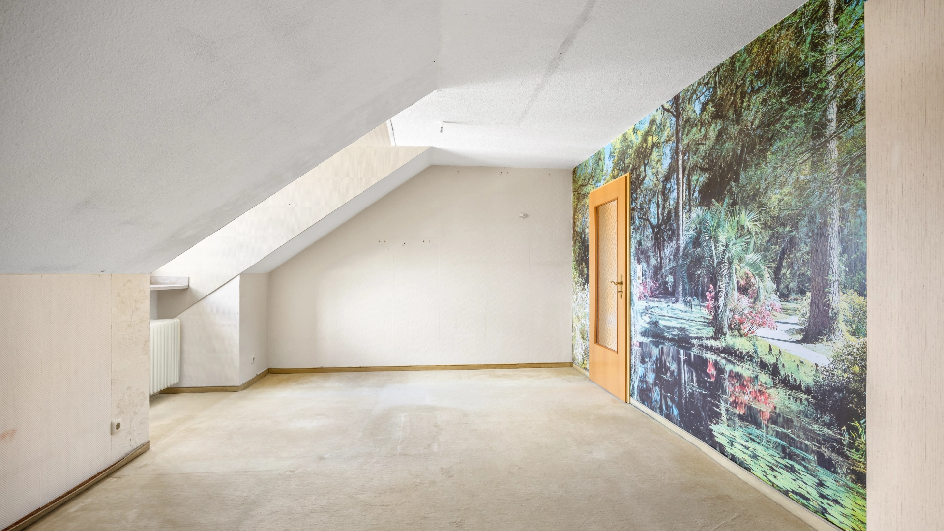 Empty attic room with slanted ceiling and decorative photo wallpaper in an apartment in Munich Berg am Laim – Rogers Immobilien
