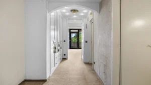 Langer heller Flur mit Einbauschränken führt zur Eingangstür der Wohnung in München-Forstenried