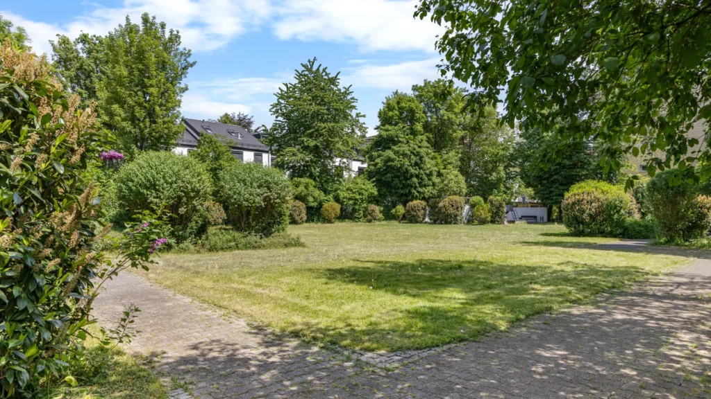 Green space with a lawn and mature trees of the residential complex in Munich-Milbertshofen