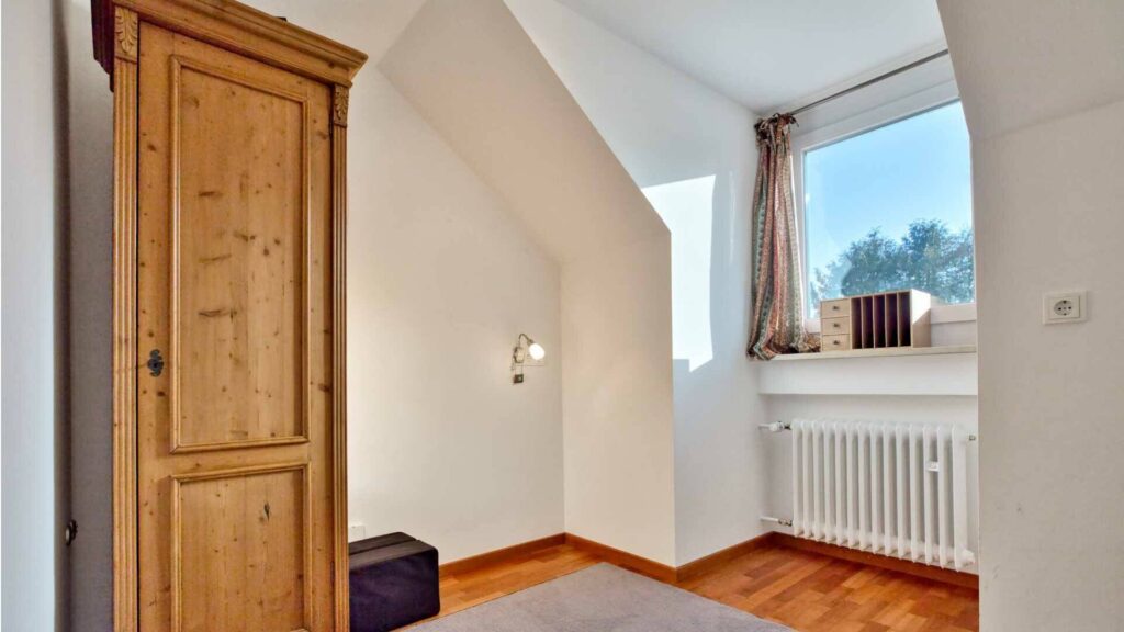 Attic room with antique wooden wardrobe and skylight in a house in Munich-Obermenzing – Rogers Immobilien