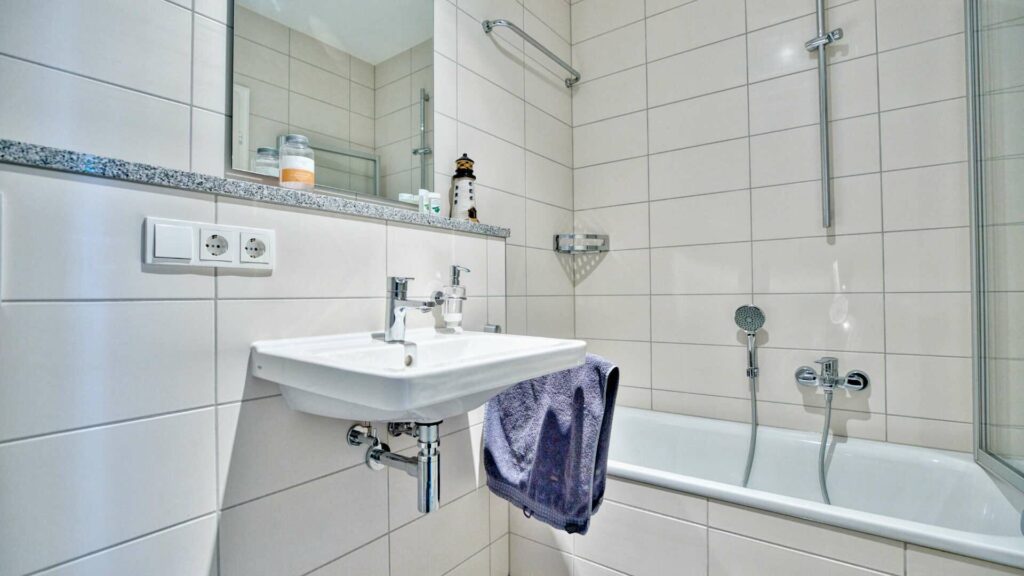 Bathroom with sink, mirror, and bathtub in a house in Munich-Obermenzing – Rogers Immobilien