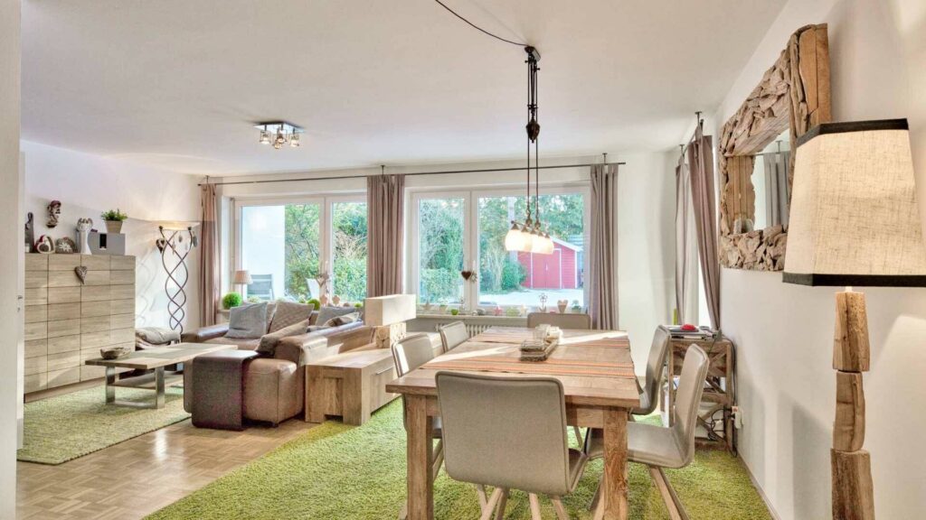 Cozy living and dining area with wooden furniture and garden view in a house in Munich-Obermenzing – Rogers Immobilien