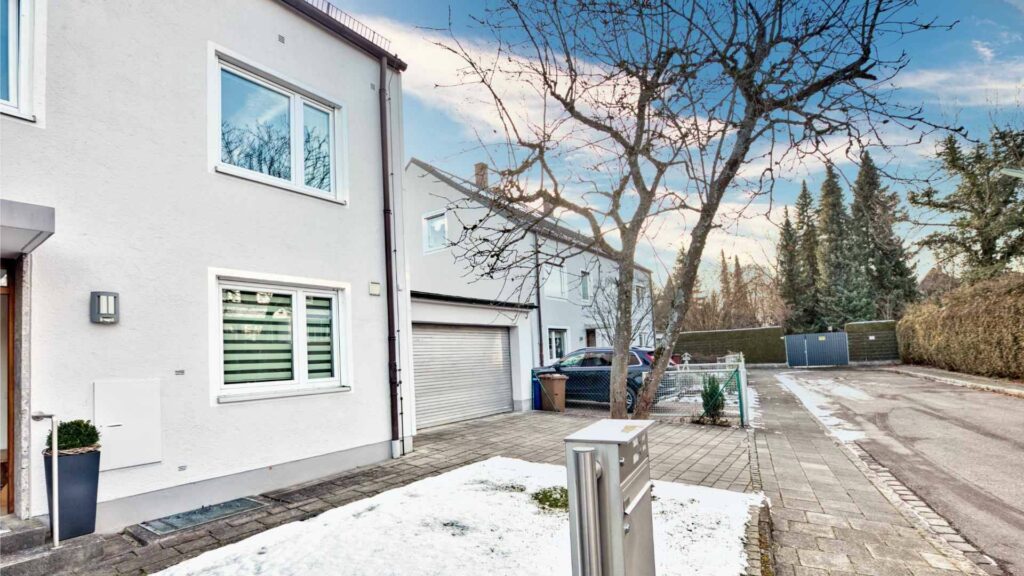 White single-family home with snow on the driveway in Munich-Obermenzing – Rogers Immobilien