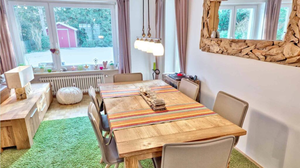 Dining room with solid wood table and view of the garden with garden shed in Munich-Obermenzing – Rogers Immobilien