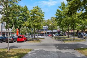 Platz mit Bäumen und Geschäften in der Nähe der Wohnung