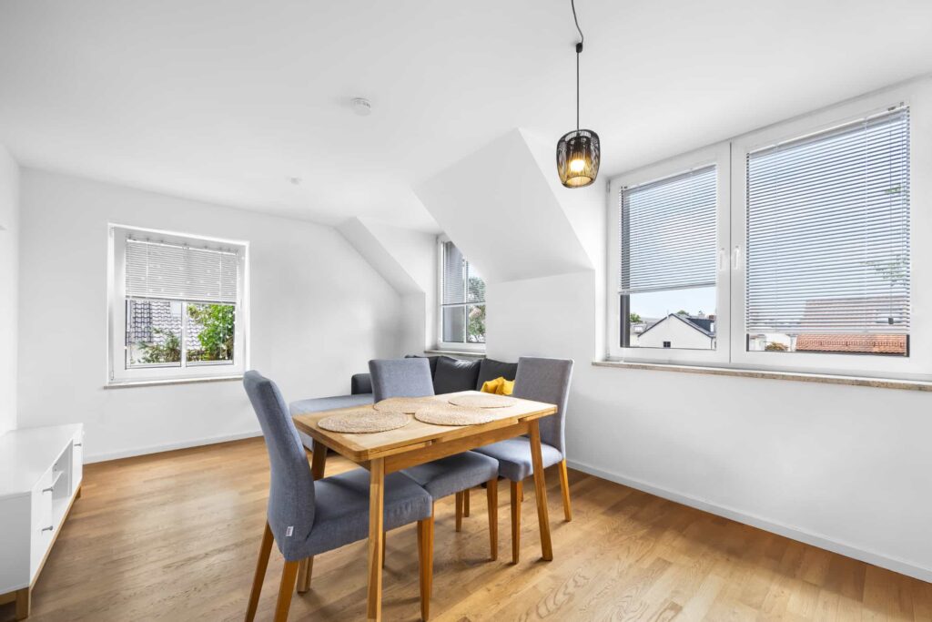 Wohnzimmer mit Essbereich, Dachschräge und großen Fenstern