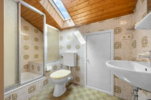 Badezimmer im Dachgeschoss mit Dusche, WC und Dachfenster