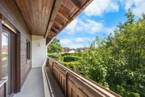 Balkon mit Holzverkleidung und Blick ins Grüne