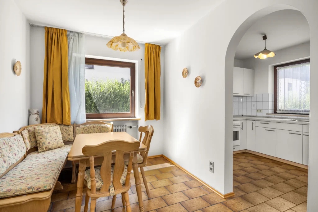 Dining area with corner bench and open access to the kitchen in original condition