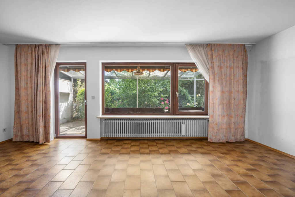 Living room in original condition with terrace access and garden view