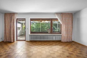 Wohnzimmer im Originalzustand mit Terrassenzugang und Gartenblick