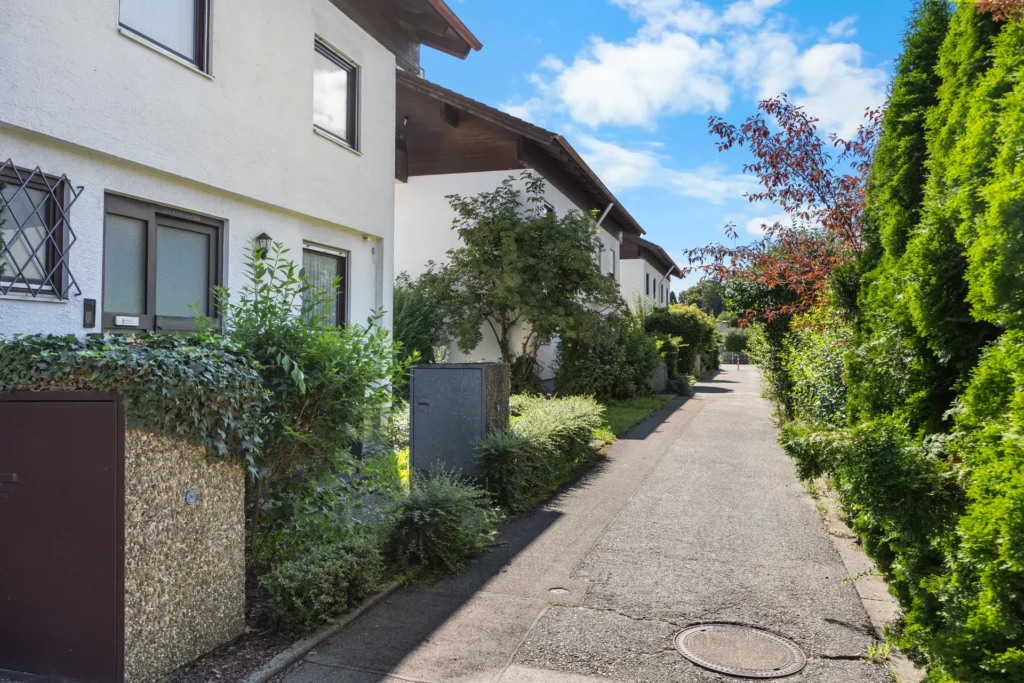 Paved access path to the semi-detached house, surrounded by hedges